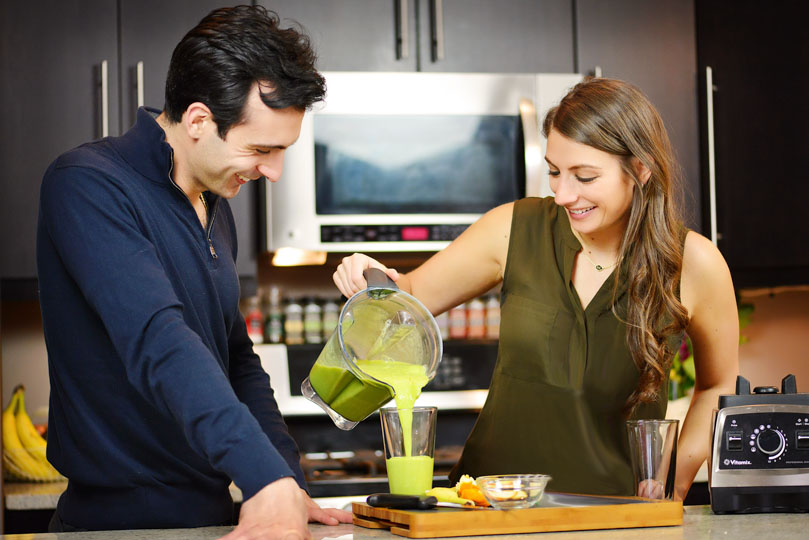 Shalva pouring Lenny Gale a green smoothie for Life is NOYOKE.