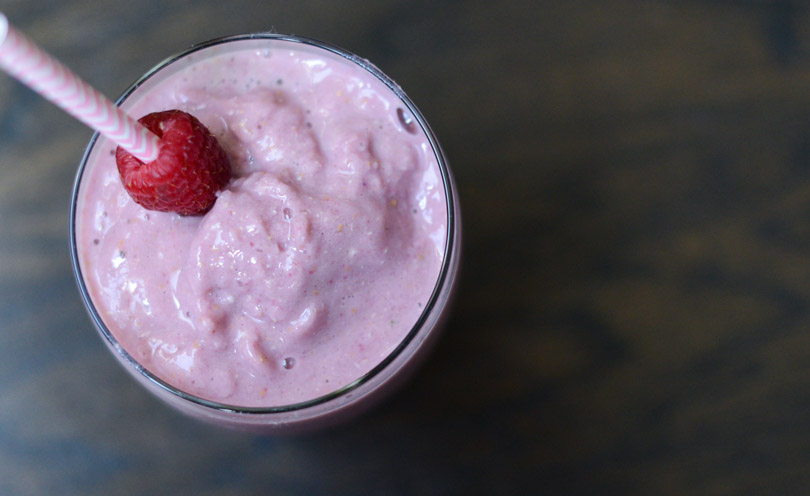 Raspberry vanilla smoothie with pink straw.