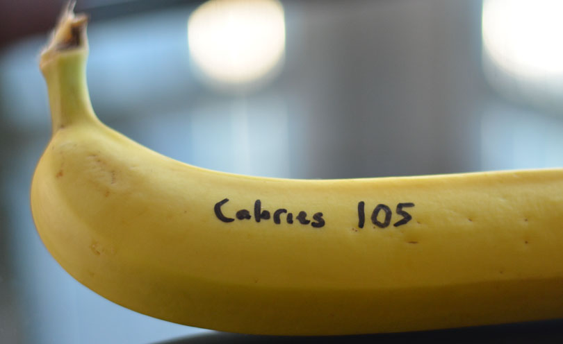 A banana with "Calories 105" written on it in permanent marker.