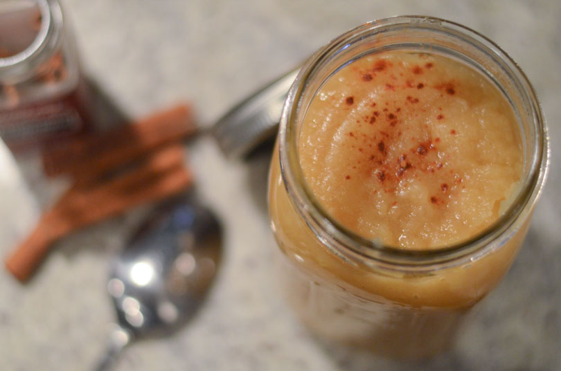 Homemade applesauce served in mason jar with cinnamon sticks.