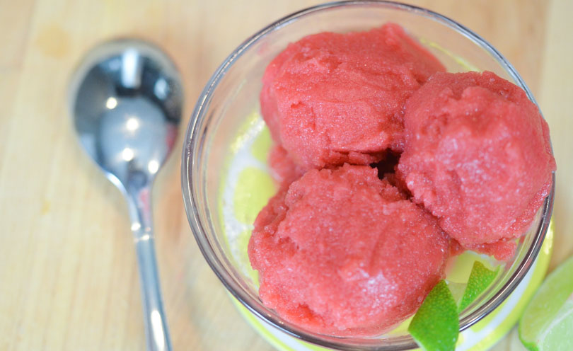 Three scoops of berry lime sorbet served in small glass dish.