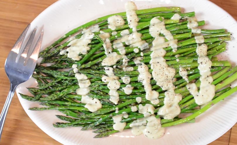 Vegan hollandaise sauce served over asparagus.