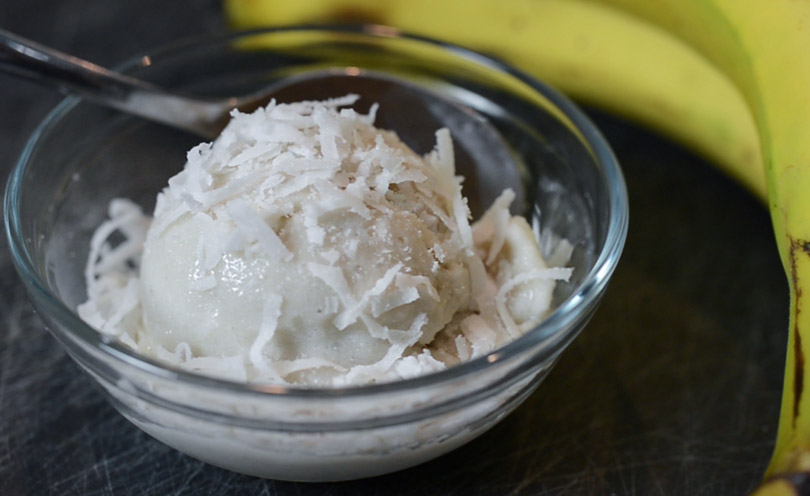 Coconut ice cream served in small clear dish.