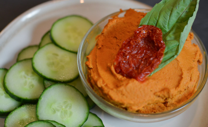 Sun dried tomato basil hummus served with cucumbers.