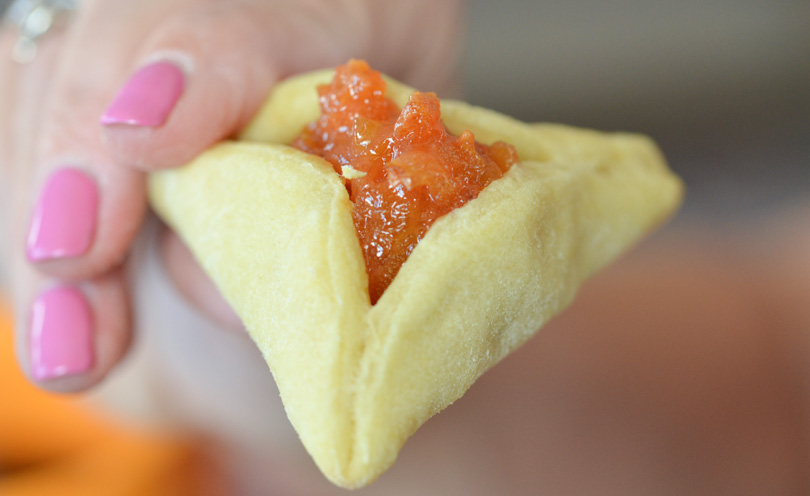 Hamentashen held by pretty lady fingers.