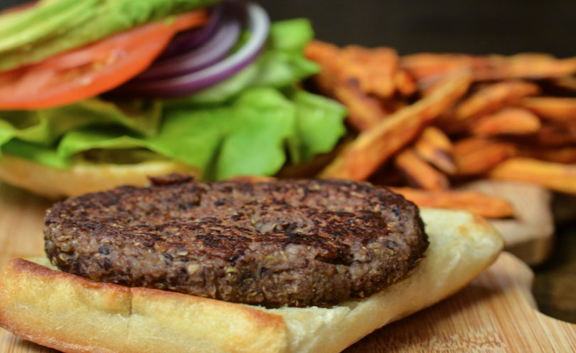 Veggie burger made in a Vitamix served open face with sweet potato fries.