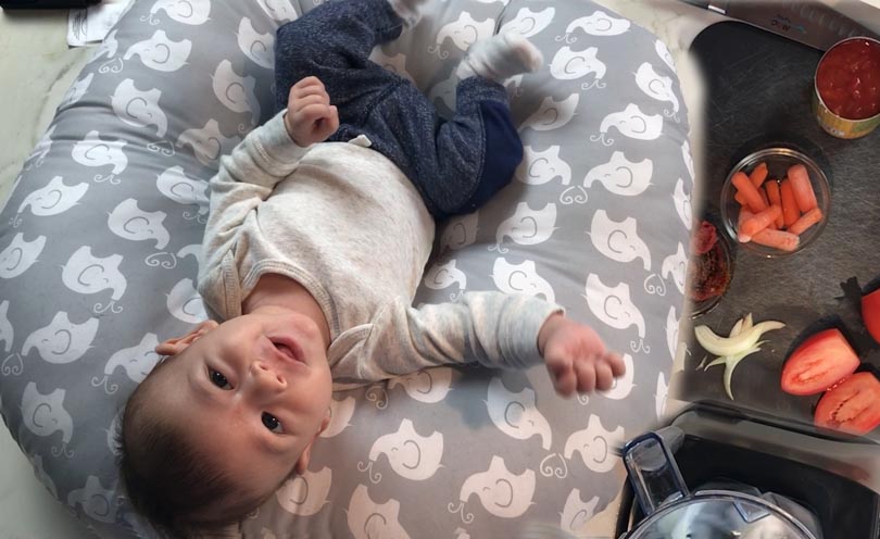 Baby on pillow with tomato soup ingredients.