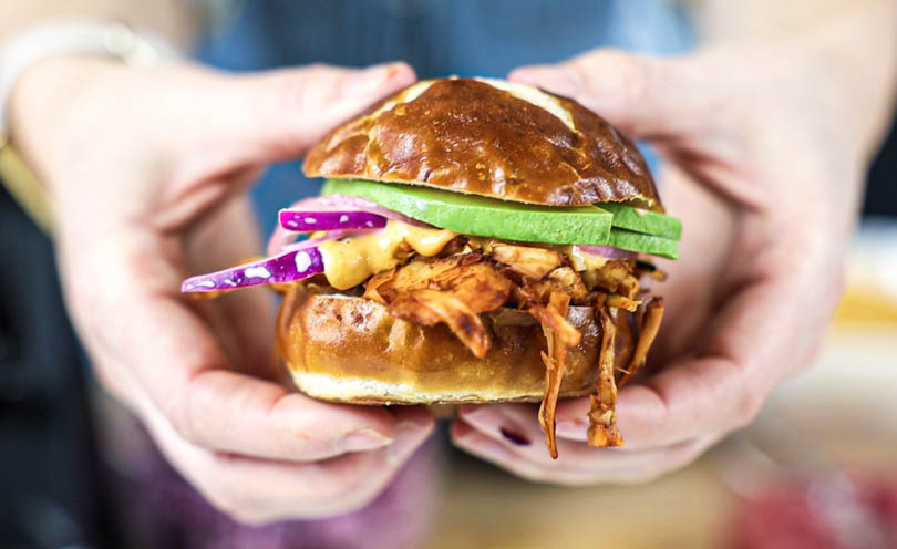 holding a pulled pork jackfruit slider