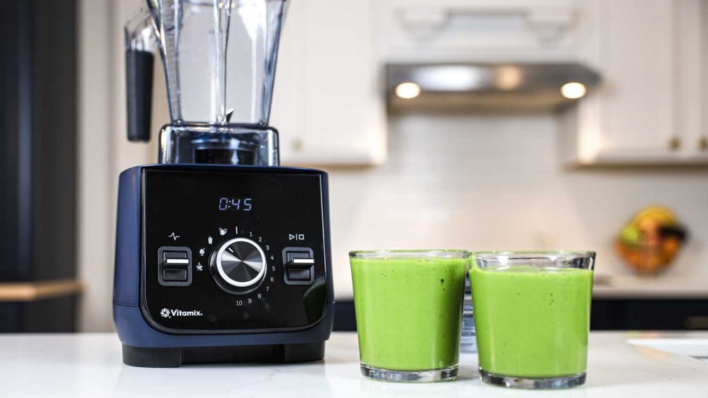 Vitamix Ascent X2 with two cups of green smoothie.